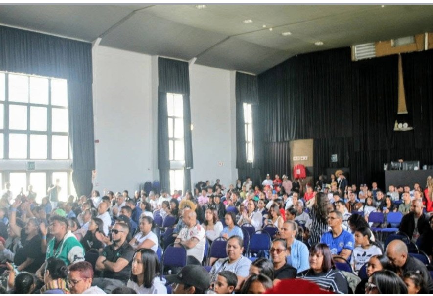 A packed community hall watching a youth showcase